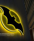 Batman Night Light Table Lamp With 3D Halo Glow mounted on wall, black bat emblem with yellow glow, solid acrylic material.