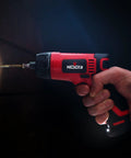 Cordless Electric Screwdriver Kit With Built In LED Light And 31 Pc Bit Set being used to drive a screw into wood, LED light on.