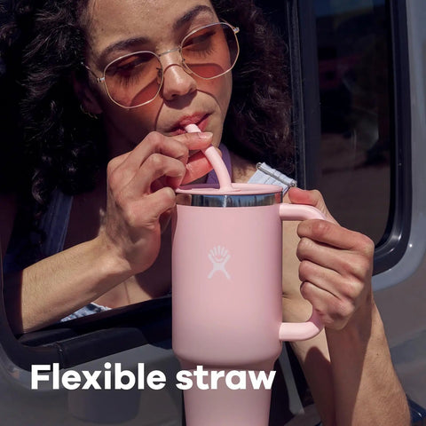 Woman sipping from a pink On The Fly 40 Oz Stainless Steel Travel Tumbler With Comfort Grip Handle And Leak Proof Straw Lid.
