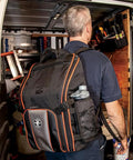 Man wearing Heavy Duty Jobsite Ready Workhorse Tool Backpack With 21 Pockets And Large Interior Water Resistant 1680D Ballistic Weave Backpack