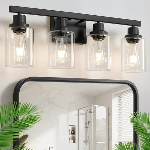 Top Shelf 4 Light Bathroom Vanity Light With Clear Glass Sleeves Matte Black Vintage Wall Sconce above mirror with plants.