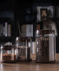 Round High Borosilicate Glass Coffee Bean Container With Real Deal Airtight Seal displaying three sizes filled with coffee and ground coffee.