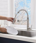 Brushed Nickel Kitchen Faucet With Pull Down Sprayer used for rinsing dishware in modern kitchen setting.