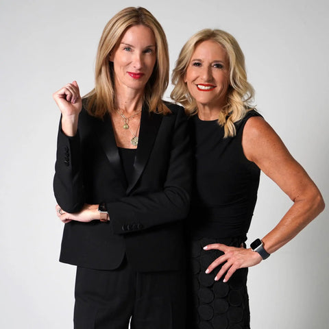 Life Is A Lazy Susan Of Straight Fire Advice And Keeping It Real Wisdom From The Beloved Podcast Duo For Crushing Burnout Laughing At Life Chaos And Staying Grounded. Image of two women in black outfits posing confidently.