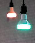 Hanging Crazy Bright Supercolor BR30 Smart Flood Bulbs 2 Pack RGB Plus Tunable White showing green and orange light