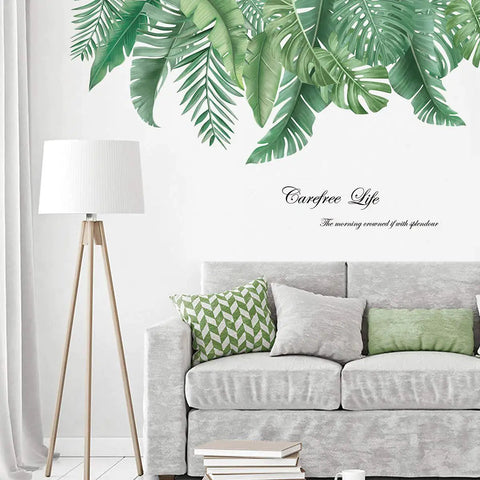 Living room with palm tree wall decals above a gray sofa, featuring green leaves; reusable stickers for decor, size 35x17 inches.
