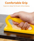 Hand holding yellow 2 Pack Push Blocks for Table Saws and Woodworking Angled Handle Push Sticks Sliding Safety Push Blocks for Woodworkers Kickback Prevention and Stock Control Great for Jointer and Saw Cutting on wood surface