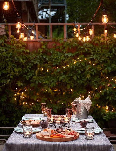 105 Ft Outdoor String Lights With 1W Dimmable S14 Bulbs, Commercial Grade Heavy Duty Waterproof Patio Bistro Market Lighting In Warm White illuminating a patio dining setup.