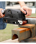 User operating 600 Watt Electric Belt Sander With Variable Speed Up To 560Rpm on a bench grinder for metal grinding.