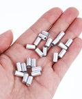 Hand holding 100 Pcs 5mm Bike Brake Cable Housing Ferrule End Caps And Crimps For Mountain And Road Bikes Must Have Silver Shifter Wire Housing Replacement Accessories Pack