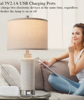 Set of 2 Modern Touch Table Lamps for Living Room and Bedroom with USB ports, white ceramic base, charging tablet on couch.