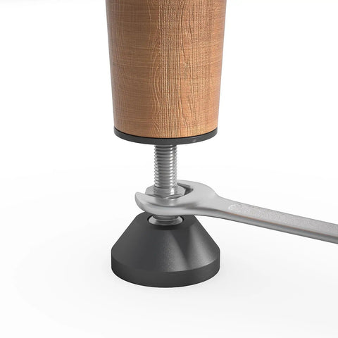 Close-up of Beefy Heavy Duty Furniture Levelers with Nut Kit adjustable feet being installed on a wood leg with a wrench.
