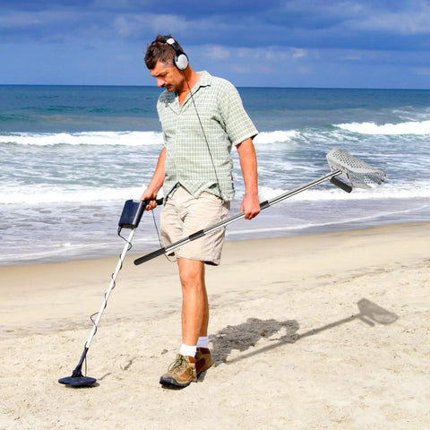 Man using metal detector and Stainless Steel Sand Scoop For Metal Detecting With Long Handle Pole Durable Beach Sand Shovel on beach