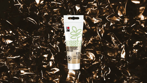 Gold Metallic Water Based Alkyd Paint Matte Finish 100 ml tube on shiny golden background