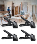 Set Of 4 Heavy Duty Wide Mouth Metal Spring Clamps For Woodworking And Diy Projects Great For Photography Backdrops Bonding Panels Hanging Fabric Papers And Small Fixtures Built From High Hardness Carbon Steel in a workshop.