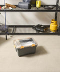 Heavy Duty IP68 Waterproof Plastic Storage Tote Featuring Tough As Nails Gasket Seal And Secure Latches Rugged Gray Bin on a floor beside storage shelves.