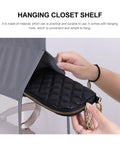 Heavy Duty Five Layer Hanging Closet Organizer With Clear View Window And Tough Rust Resistant Steel Hook For Straight Up Wardrobe Storage And No Sweat Travel Packing showing a hand reaching for a quilted black pouch in the organizer.