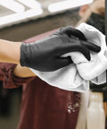 Gloved hand cleaning a mirror with Bar Mop Towels Value Pack Of 60, 14 By 17 Inches, Absorbent And Durable Multipurpose Cleaning Rags, White