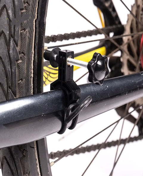 Ultra Portable Bike Wheel Truing Stand For On The Go Rim Adjustment attached to a bike frame, showing detail of clamp mechanism.