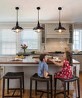 Black Pendant Light Set 3 Pack, Industrial Farmhouse Pendant Lighting over kitchen island with children seated. 10.5 Inch lights.