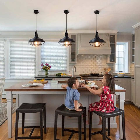 Black Pendant Light Set 3 Pack, Industrial Farmhouse Pendant Lighting over kitchen island with children seated. 10.5 Inch lights.