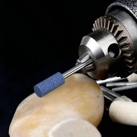 Close-up of a sanding bit attached to a rotary tool smoothing a metal surface, part of the Sanding Bits for Rotary Tool Set with One Eighth Inch Shank, Fourteen Pieces Beefy Aluminum Oxide Grinding Stones for Metal Rust Removal, Smoothing, Deburring, and Sharpening.