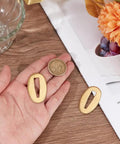 Hand holding Two Piece Brass Seppa Spacers Set for Japanese Samurai Swords Gold Finish Katana Washers with coin for size comparison