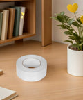 Super Smooth Removable Double Sided Tape 5Cm X 164Ft Transparent Pet Roll on a desk next to books and a potted plant.