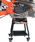 Detachable Dirt Bike Stand With Wheels And Tool Tray, Heavy Duty Maintenance Stand For Dirt Bikes And Pit Bikes, Movable Motorcycle Lift With Locking Casters, No Fuss, Easy Roll, Sturdy Iron Frame, 330 Pound Capacity shown under a bike