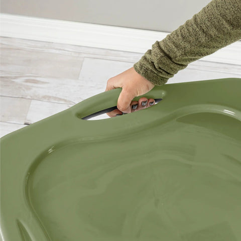 Hand gripping the handle of a Heavy Duty 17.5 Gallon Plastic Storage Bin With Clear Lid And Full Length Through Wall Handles Gray Opaque Base Stacks Tight 70 Quart Tote For Blankets And Gear.