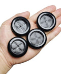 Hand holding four black rubber grommets for 1.5-inch holes, Eight Pack One And A Half Inch Drill Hole Rubber Grommets Black Double Sided Cable Plugs For Wire Protection Durable Natural Rubber Dust Proof Insulation For Wiring Harnesses Great For Automotive Wiring And Electrical Projects.