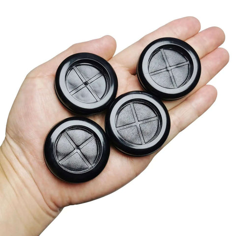 Hand holding four black rubber grommets for 1.5-inch holes, Eight Pack One And A Half Inch Drill Hole Rubber Grommets Black Double Sided Cable Plugs For Wire Protection Durable Natural Rubber Dust Proof Insulation For Wiring Harnesses Great For Automotive Wiring And Electrical Projects.