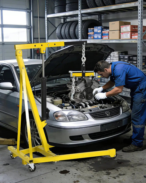 Heavy Duty Hydraulic Engine Hoist With No Sweat Pumping Lever And Adjustable Telescoping Boom lifting engine in a garage setting.