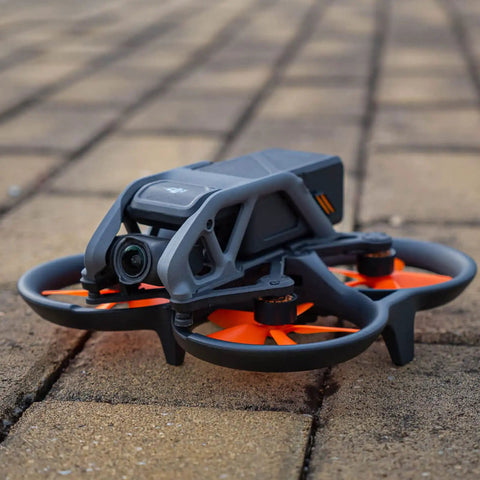 FPV drone with Avata Drone Propellers Replacement Set Orange 8 Pack, lightweight PC blades installed on outdoor pavement.