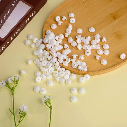 120 Pack White Pegboard Hook Stoppers Lock It Down And Keep Gear Secure Heavy Duty Silicone Safety Clips scattered on a wooden tray.