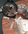 8 Inch Precision Horizontal Vertical Rotary Table With 6 Inch Three Jaw Chuck and tools on wooden surface.