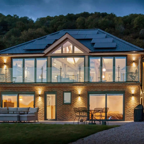 Modern house with outdoor lighting, featuring Integrated LED Cylinder Up Down Outdoor Wall Light on porch and walls, IP65, 4-pack.