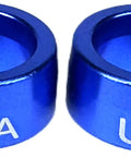 Two blue anodized aluminum steering wheel column sleeve bushings with USA engraving.