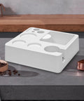 Heavy Duty Coffee Tamper Station With Pop Out Grounds Container, Clean White Espresso Tamping Holder For Home Bars on countertop.