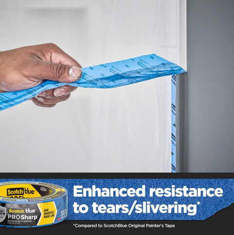 Hand applying PROSharp Painter's Tape 1.5 in x 60 yd, 3-Pack - Edge-Lock+ for sharp paint lines on a wall