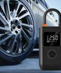 Slick Wireless Rechargeable Car Air Compressor Fast Tire Inflator With Easy Digital Display Auto Shutoff beside a car wheel.