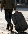 Person rolling military grade rolling duffle bag on street