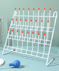 Compact Lab Glassware Drying Rack For Beakers And Flasks, white steel stand with orange tips, holds test tubes.