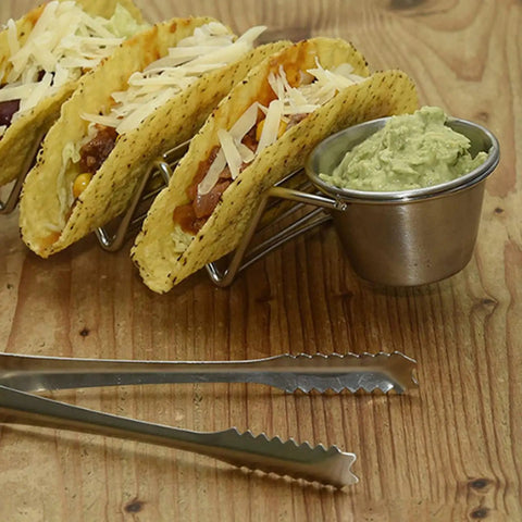 Stainless Steel 3 Grid Taco Holder with V Shaped Slots and No Spill Sauce Cups on wooden table, loaded with tacos and guacamole