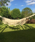 Handmade Cotton Woven Hammock Chair With Rope Swing And Crochet Fringe in garden, showcasing natural white boho vibes
