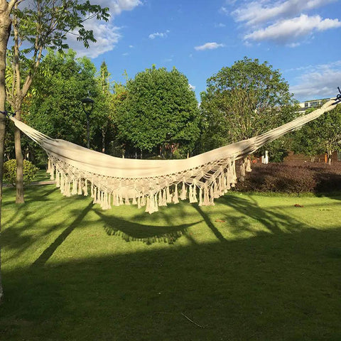 Handmade Cotton Woven Hammock Chair With Rope Swing And Crochet Fringe in garden, showcasing natural white boho vibes