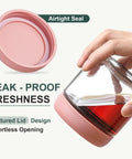 Hand holding a glass jar with pink airtight lid, featuring leak-proof freshness for Six Pack 10oz Glass Jars With Airtight Lids For Overnight Oats.