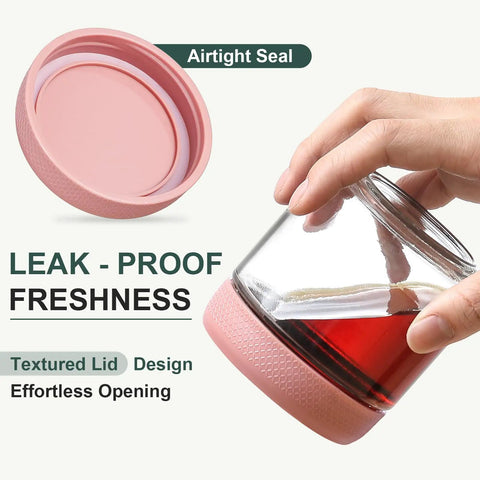 Hand holding a glass jar with pink airtight lid, featuring leak-proof freshness for Six Pack 10oz Glass Jars With Airtight Lids For Overnight Oats.