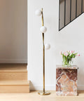 Nola Mid Century Modern 3 Globe Floor Lamp For Living Room And Office, LED Gold Finish Pole, near marble table with pink flowers
