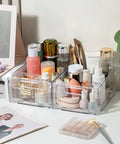Foldable Plastic Storage Baskets With Handles 2 Pack on a desk, filled with cosmetics and brushes, visible side view.